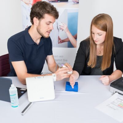 Mann führt Screening bei einer Mitarbeiterin durch
